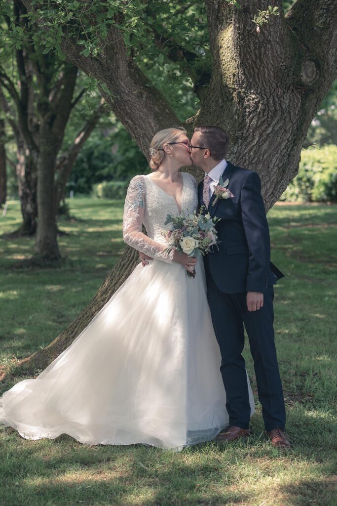 Bride and groom kissing, romantic forest wedding, outdoor wedding photography, tree wedding kiss, love in nature
